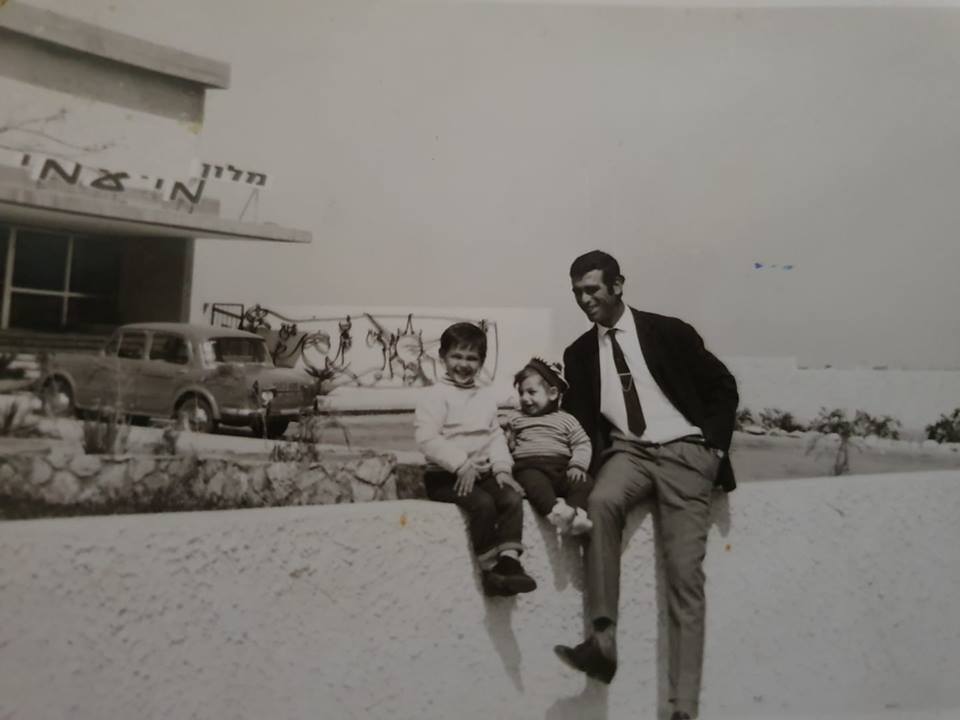 אבי בן עמי, אחיו יעקב ואביהם סעדיה. ברקע: מלון מיעמי בשנת 1970 | באדיבות אבי בן עמי