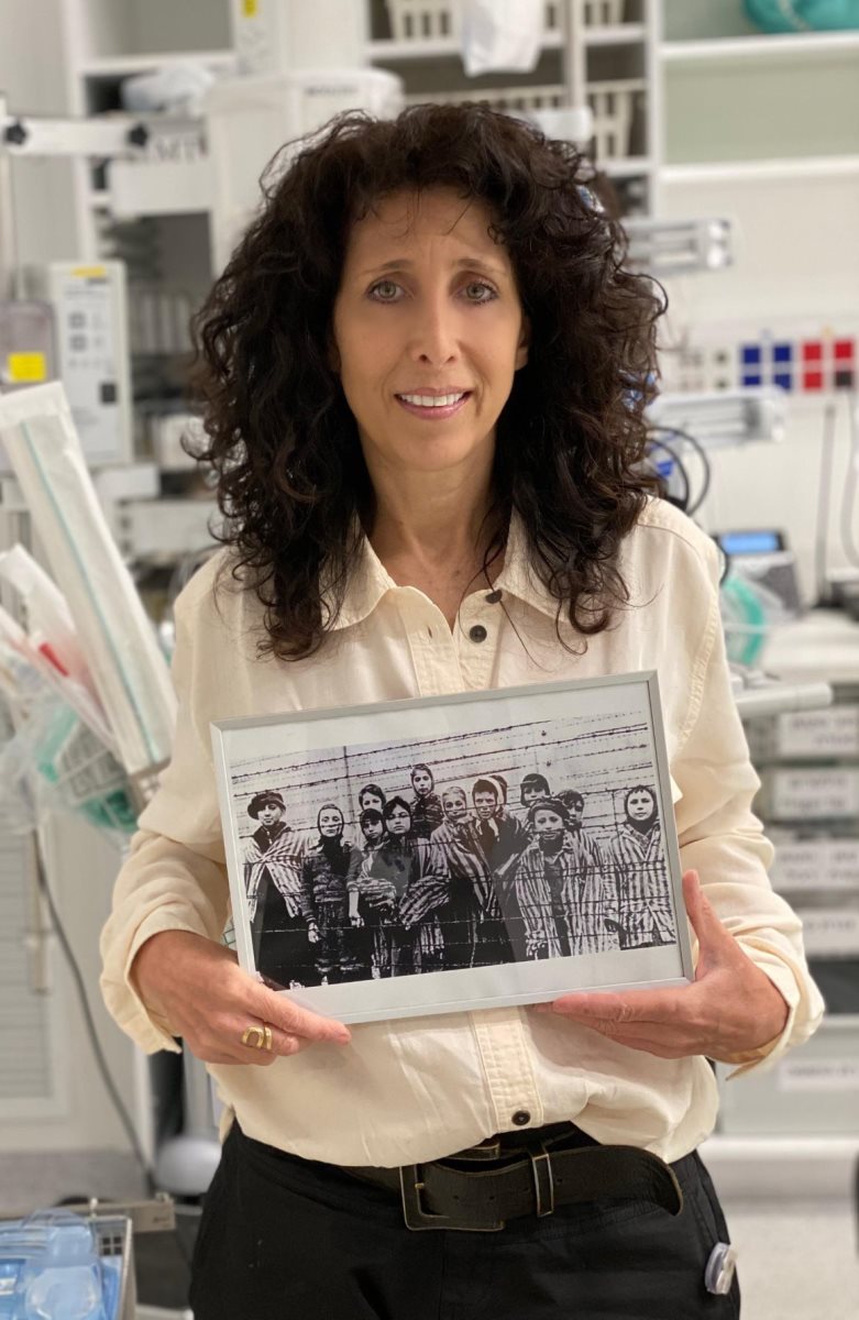 ד"ר דברה ווסט אוחזת בתמונת השחרור המפורסמת מאושוויץ, בה מופיעות שתיים מדודותיה. קרדיט: דוברות אסותא