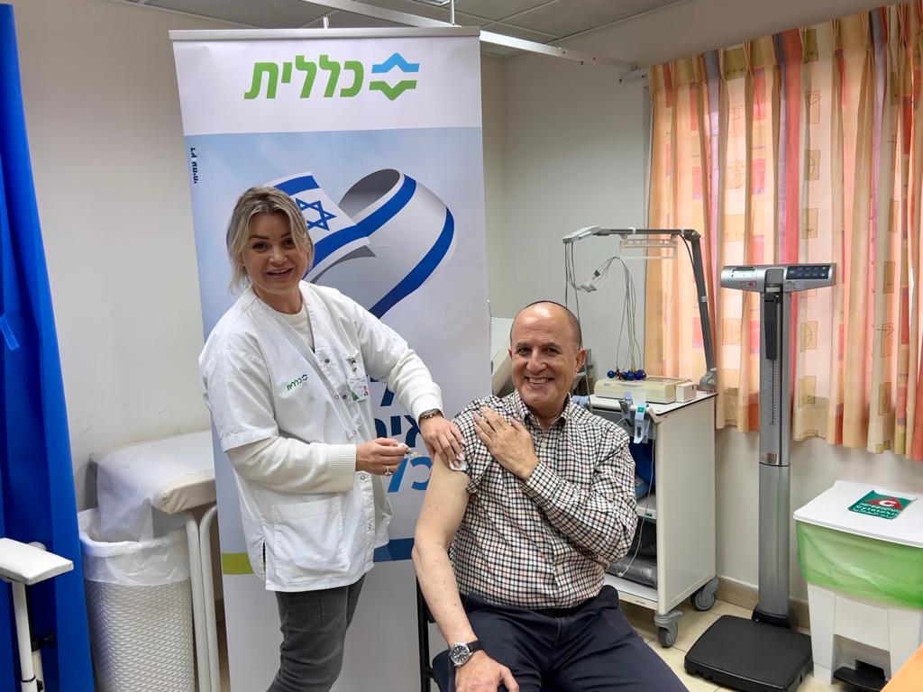 האחות אנא אללוף מחסנת את ראש העיר ד״ר יחיאל לסרי - מרפאת כללית אשדוד א׳