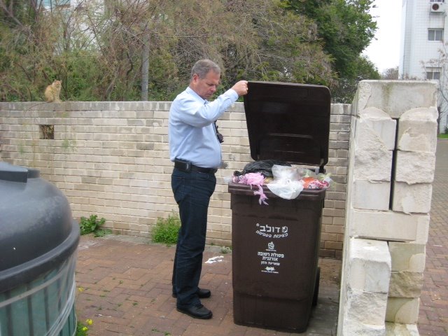 שלמה רוטנברג, ראש מינהל התפעול, בודק פח של פסולת רטובה ברחוב מטולה ברובע ט'